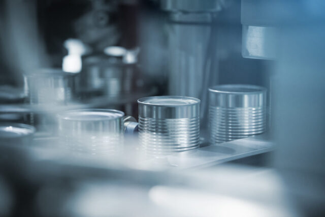 Photo of aluminum Cans moving on aluminum can production line in a factory.